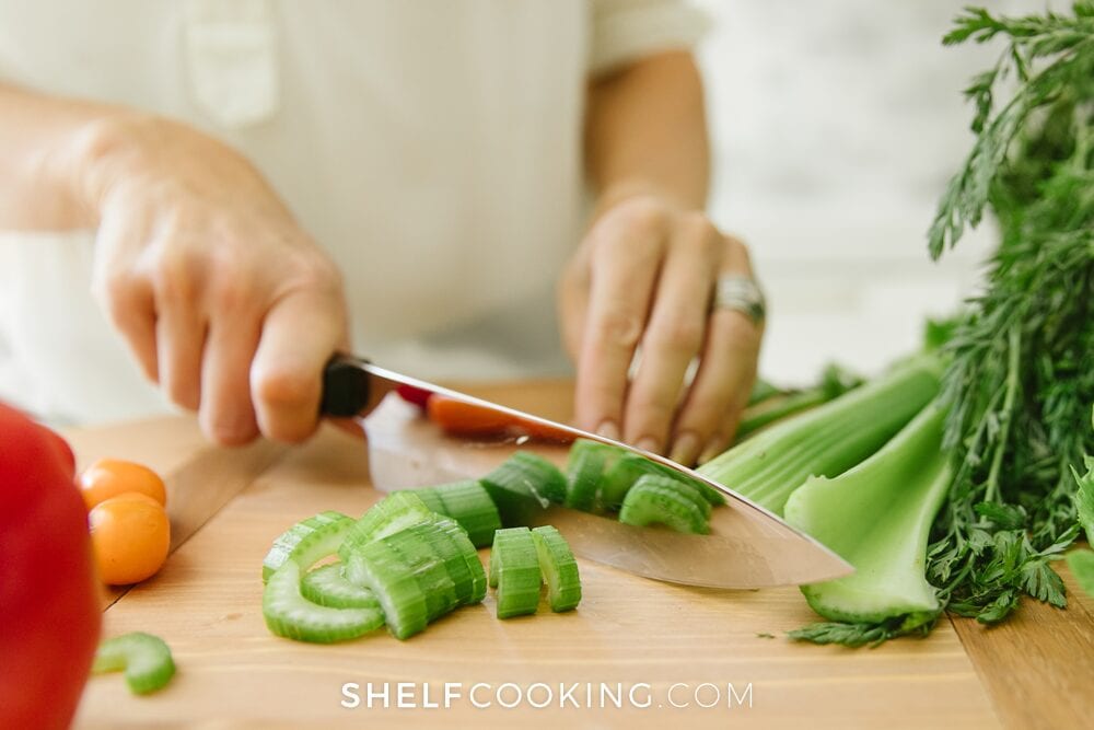 Jordan chopping celery on a cutting board, from Shelf Cooking
