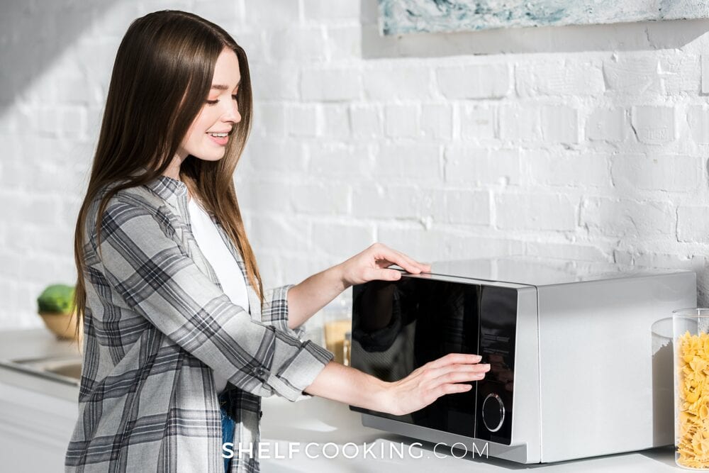 Woman thawing food in the microwave, from Shelf Cooking