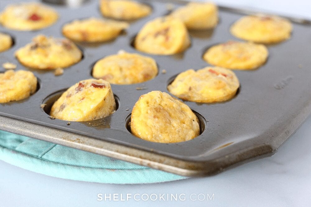 Mini egg muffins in a muffin tin on a counter, from Shelf Cooking