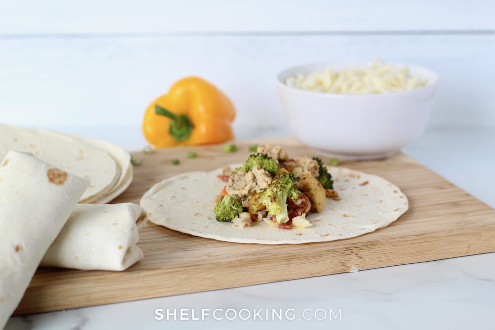 Breakfast burrito laid out on a cutting board, from Shelf Cooking