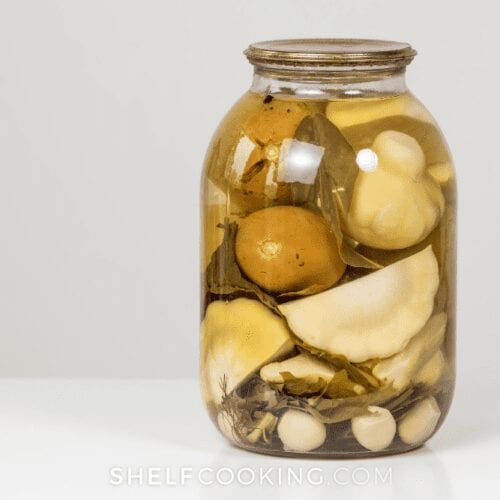 jar of pickle juice with veggies on a white counter