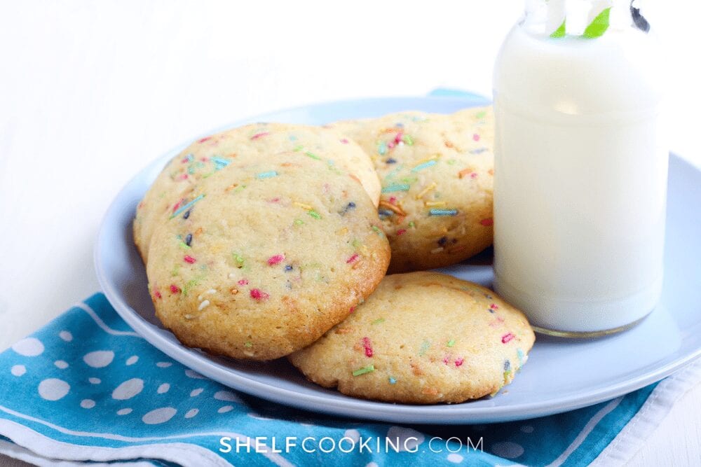 plate of cake mix cookies with sprinkles next to glass of milk, from Shelf Cooking