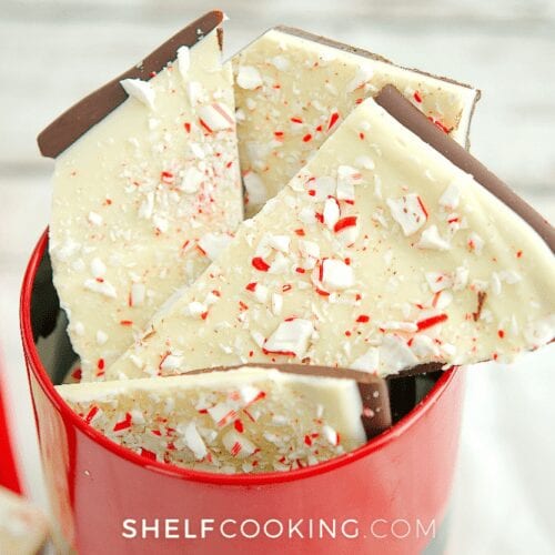 red mug filled with white chocolate peppermint bark, from Shelf Cooking