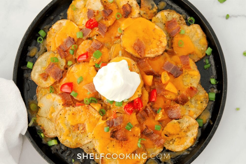 a plate of loaded sliced baked potatoes nachos, from Shelf Cooking