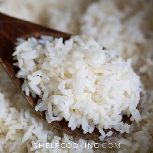 Oven-baked rice in a wooden spoon from Shelf Cooking.