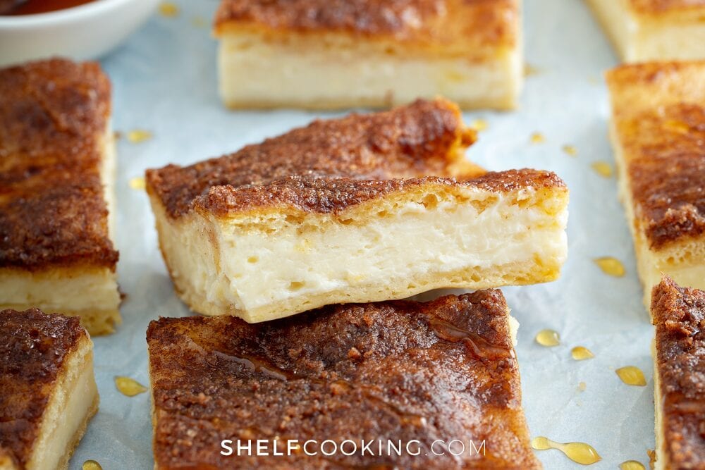 Sopapilla cheesecake squares on the counter from Shelf Cooking. 