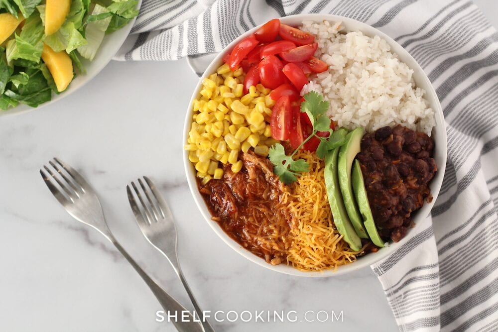 Pork bowl with rice, avocado, beans, corn, and tomatoes from Shelf Cooking. 
