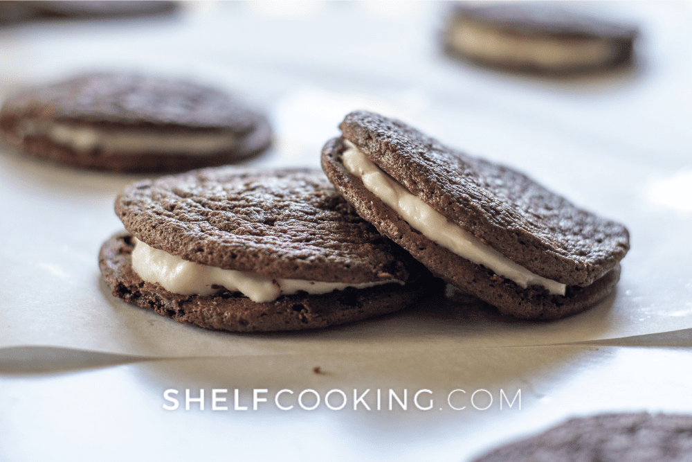 Image of homemade oreo sandwich cookies resting on parchment paper. - Shelf Cooking