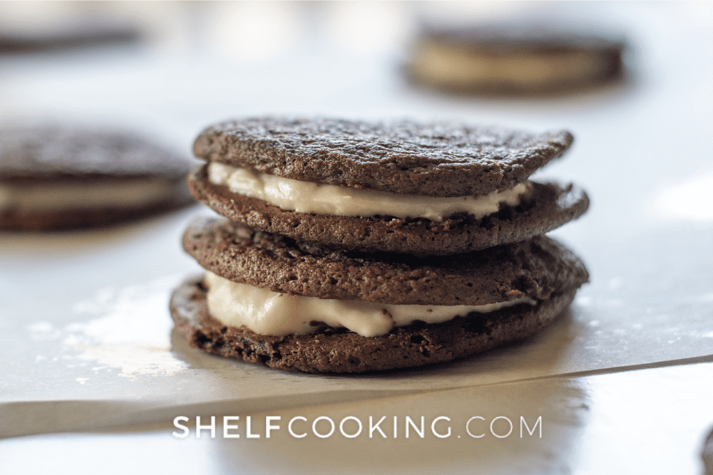 Image of stacked two homemade oreo cookies on top of of parchment paper. - Shelf Cooking