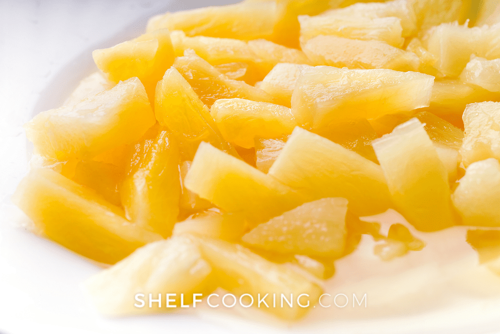 Close up of canned pineapple tidbits in a bowl to be used for pineapple rice. - Shelf Cooking