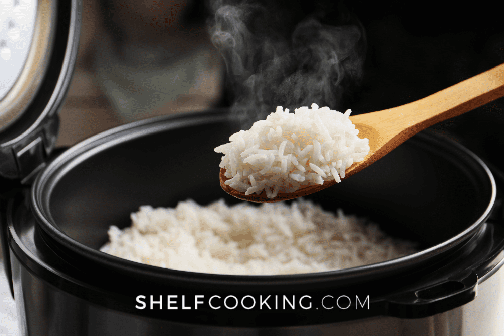 Instant pot full of cooked white rice, with a wooden spoon with rice held above it. - Shelf Cooking