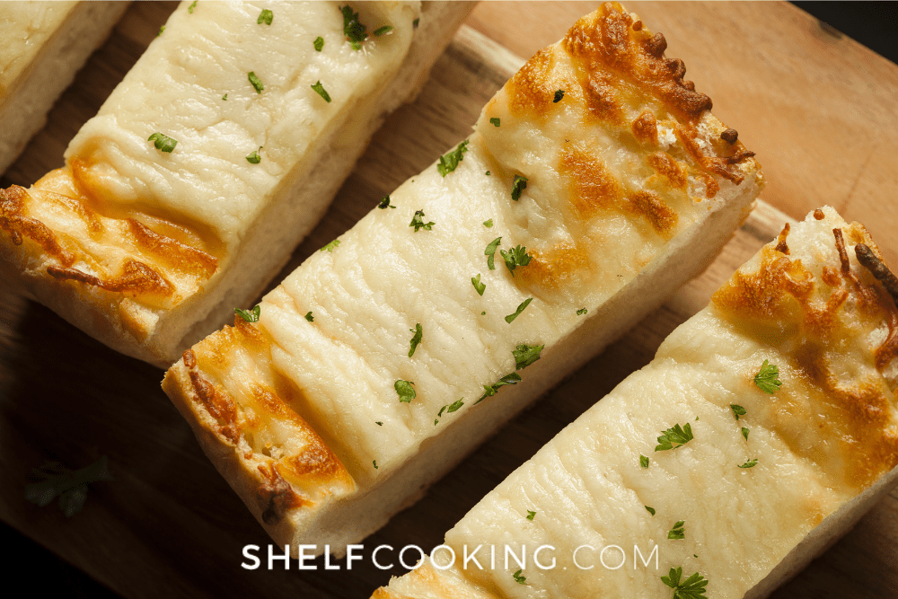 Overhead image of slices of cheesy garlic bread for a date night dinner at home. - Shelf Cooking